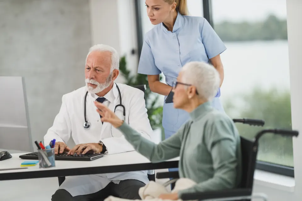 A doctor and a nurse with a patient at a clinic desk